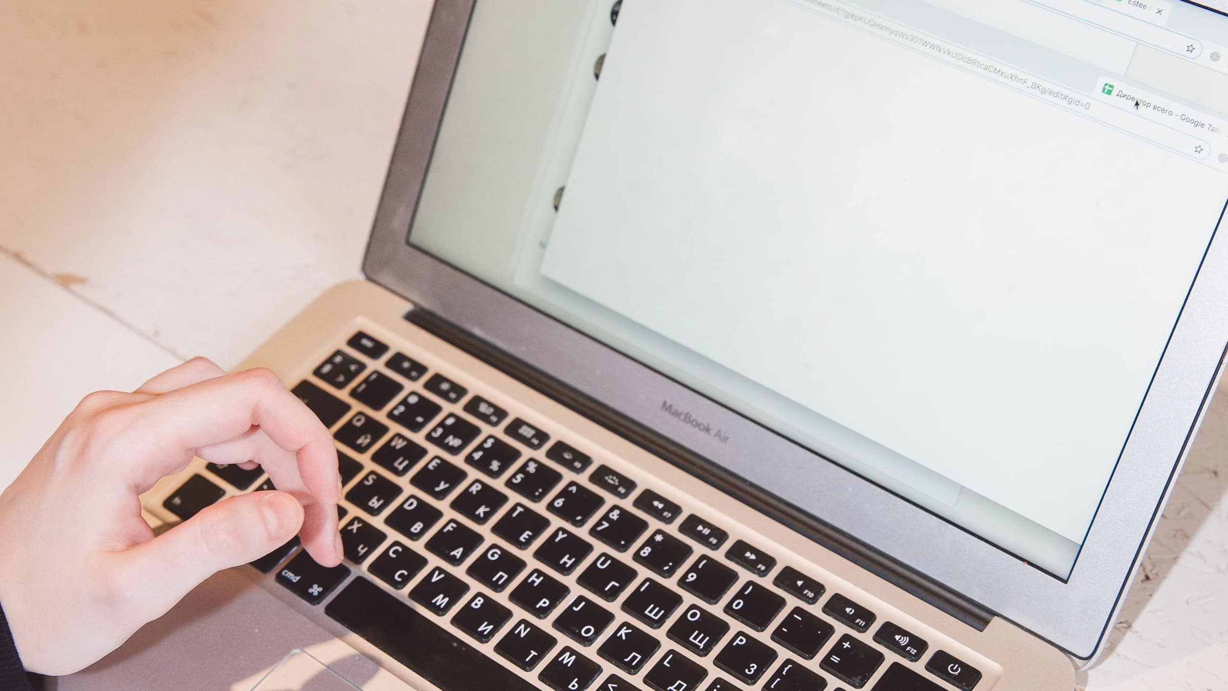 Hands typing on a laptop at a light desk
