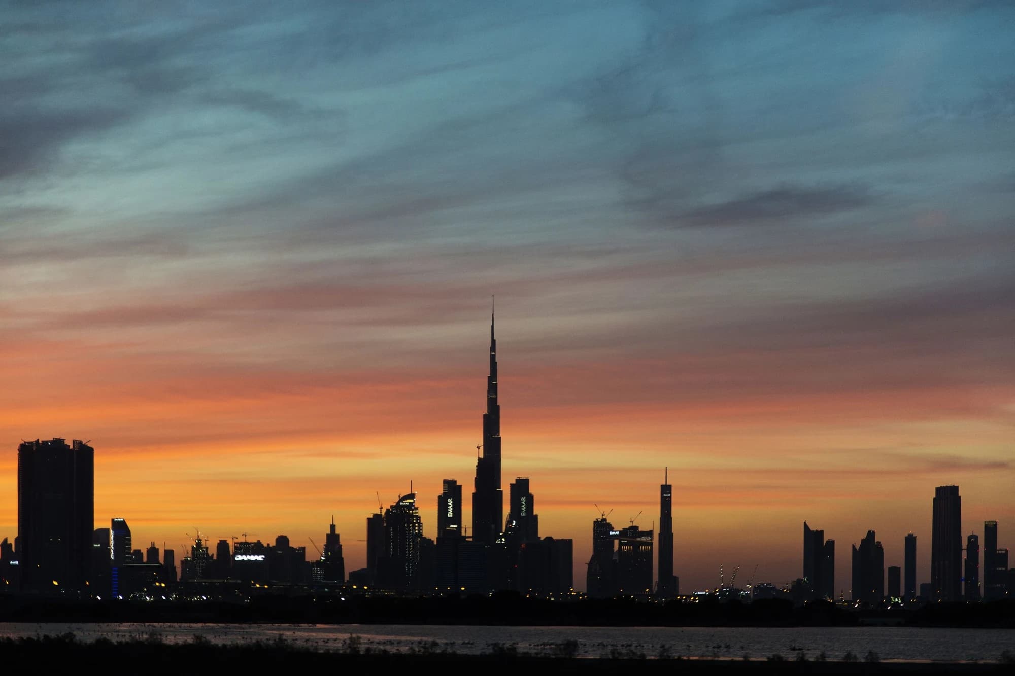 Burj Khalifa and the Dubai skyline beneath a colourful sunset sky