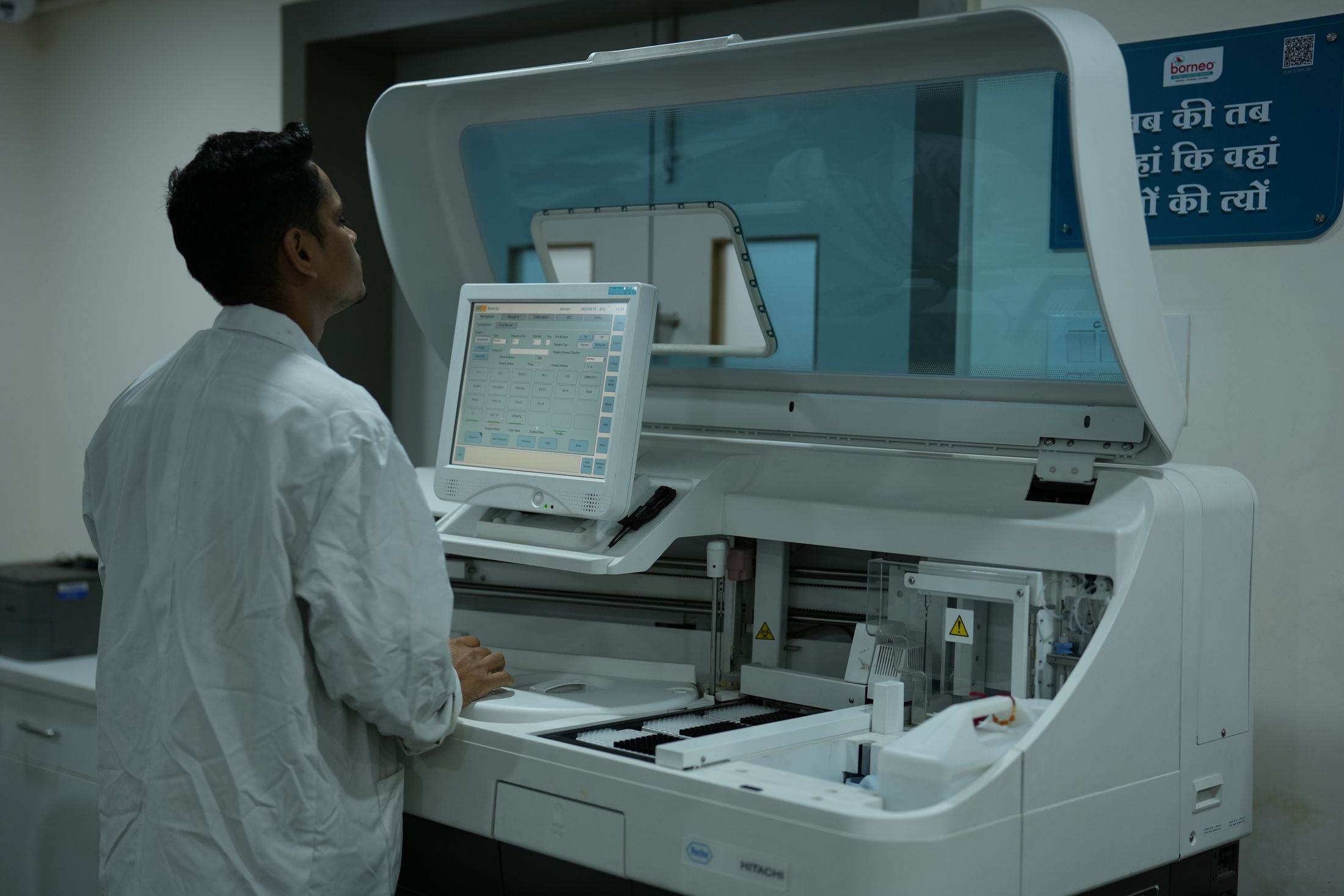 Laboratory technician operating automated quality control equipment